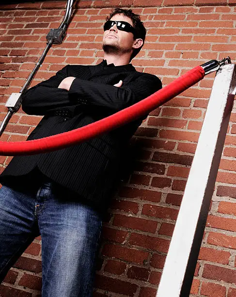 A serious bouncer stands outside a bar.Taken at GTALypse 08.Also available: