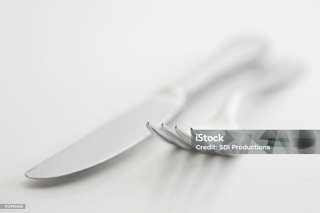 Серебро нож и вилка лежал на и против Белый фон - Стоковые фото Без людей роялти-фри