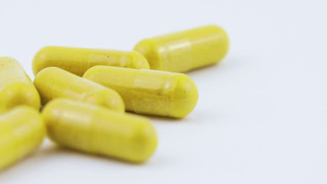 Capsules With Nutrient Supplements Falling on White Background