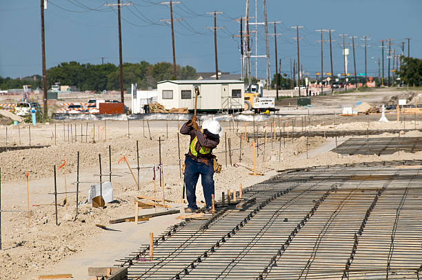 Faceless Man Drives Stake at Construction Site stock photo