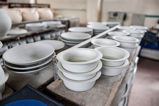 Ceramic pieces ready to be painted at a pottery factory - small business concepts