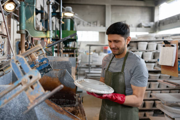 istock Employee working at a pottery factory making a plate 1729966332