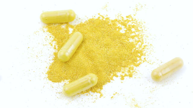 Capsules With Turmeric and Thistle on White Background