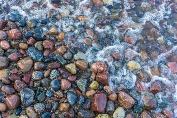Sea spray on colorful stones on a stony beach