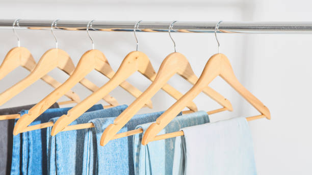 jeans on hangers close-up. trousers from blue, light blue and gray jeans close-up. jeans on hangers close-up. trousers from blue, light blue and gray jeans close-up. online shopping concept with copy space clothes hanger rod stock pictures, royalty-free photos & images
