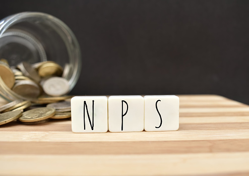 A closeup picture of NPS letters placed in front of coins splilled out of jar