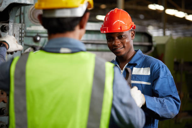 istock african technician giving or sending wrench to worker for fixing a machine 1729978619
