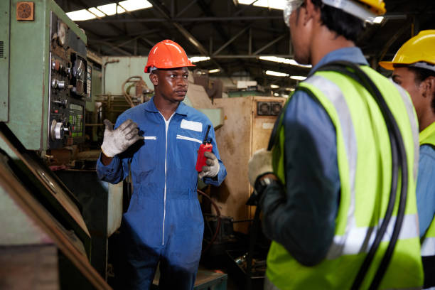 istock male african foreman training and teaching how to use machine control with workers in factory 1729978625
