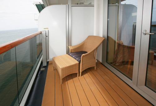 Wicker chair and ottoman on verandah deck of cruise ship.