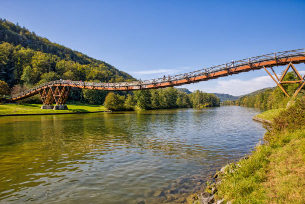 il famoso ponte pedonale di legno tatzlwurm sul canale reno-meno-danubio con gli escursionisti alla luce del sole e al cielo azzurro - essing foto e immagini stock