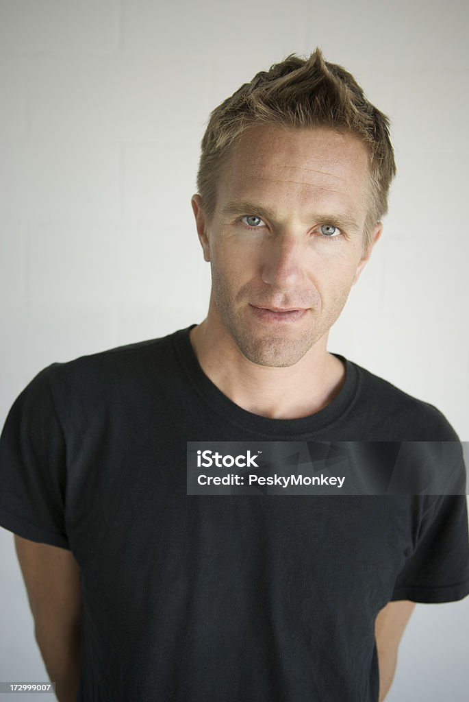 Portrait of Young Man in Black T-Shirt Spiky Hair Guy in a black t-shirt with pointy hair looks at the camera with a blank expression Adult Stock Photo