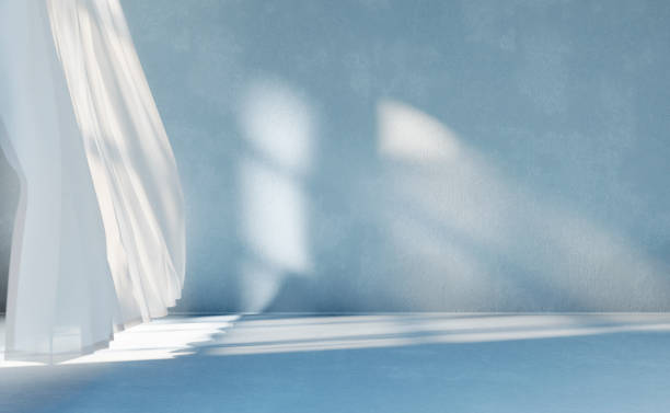 Empty room with shade from window light and white curtains.