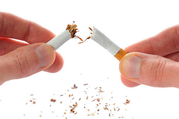 Quit smoking, cigarette broken in half, isolated on white Quit smoking, cigarette in hands broken in half, isolated on white, studio shot. cigarette photos stock pictures, royalty-free photos & images