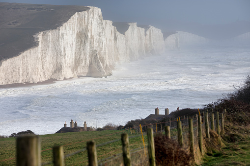 Dramatic waves in the English Channel set against the majestic white cliffs known as the Seven Sisters, East Sussex, UK