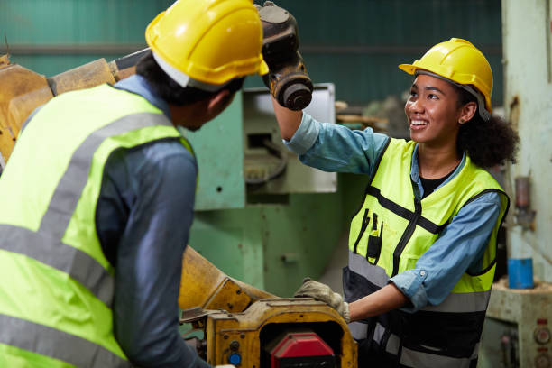 istock worker or engineer checking and fixing a machine with coworker in the factory 1730000288