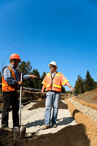 maschio maturo project manager monitorare prevenzione dell'erosione del suolo l'attrezzatura di sicurezza arancione - engineer environment orange manual worker foto e immagini stock