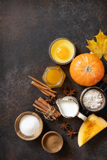 istock Baking background for Thanksgiving or autumn holidays. Homemade fall baking background with ingredients pumpkins, sugar, flour, nuts, eggs and spices on a dark stone table. View from above. Copy space. 1730008184
