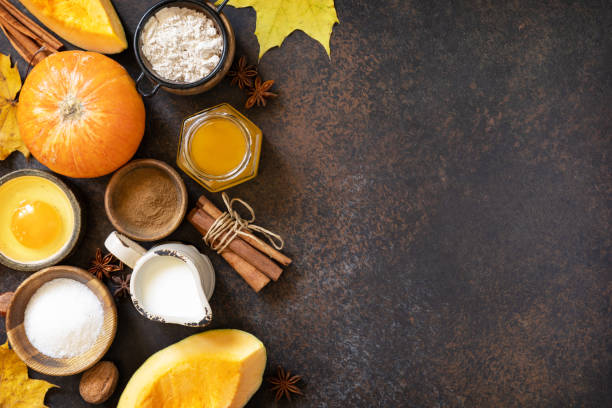 istock Homemade fall baking background with ingredients pumpkins, sugar, flour, nuts, eggs and spices on a dark stone table. 1730008185