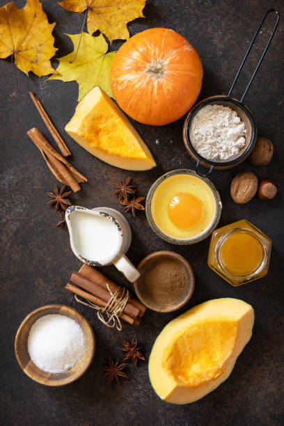istock Homemade fall baking background with ingredients pumpkins, sugar, flour, nuts, eggs and spices on a dark stone table. 1730008186