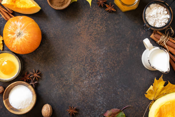 istock Baking background for Thanksgiving or autumn holidays. Homemade fall baking background with ingredients pumpkins, sugar, flour, nuts, eggs and spices on a dark stone table. View from above. Copy space. 1730008189