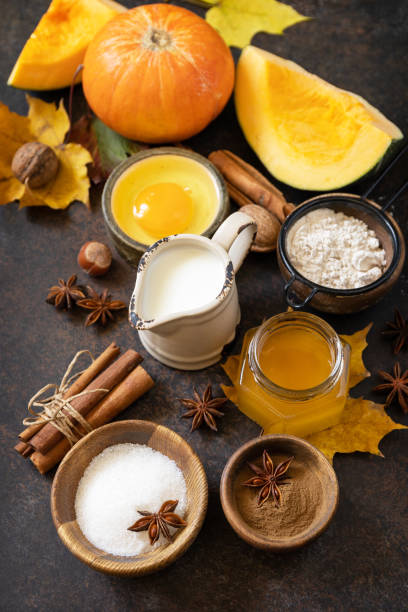 istock Homemade fall baking background with ingredients pumpkins, sugar, flour, nuts, eggs and spices on a dark stone table. 1730008195