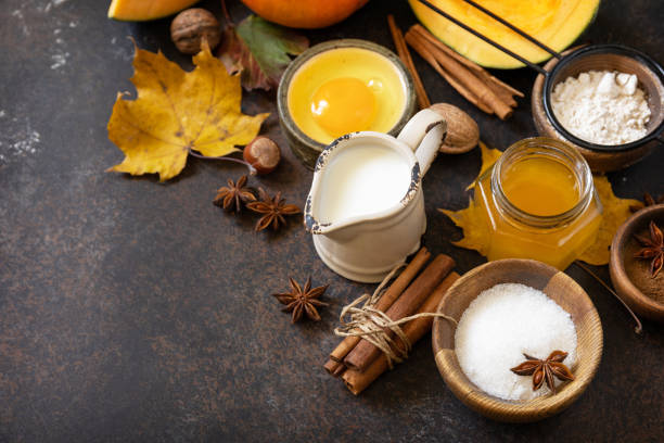 istock Baking background for Thanksgiving or autumn holidays. Homemade fall baking background with ingredients pumpkins, sugar, flour, nuts, eggs and spices on a dark stone table. Copy space. 1730008204
