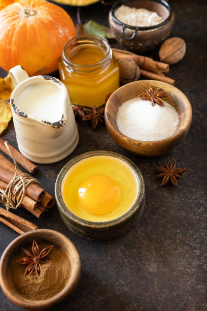 istock Baking background for Thanksgiving or autumn holidays. Homemade fall baking background with ingredients pumpkins, sugar, flour, nuts, eggs and spices on a dark stone table. 1730008238