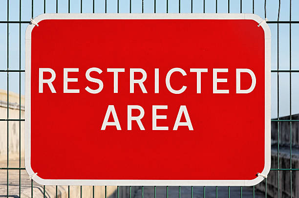 RESTRICTED AREA sign attached to wire fence stock photo