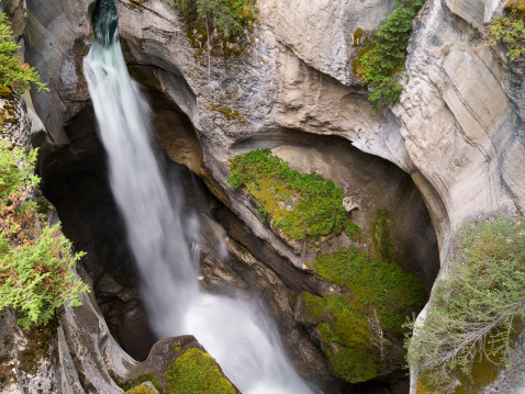 Looking down from a great height at a waterall in Maligne Canyon.