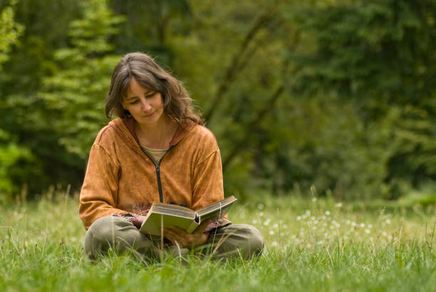 istock Middle aged woman reading in park 173003047