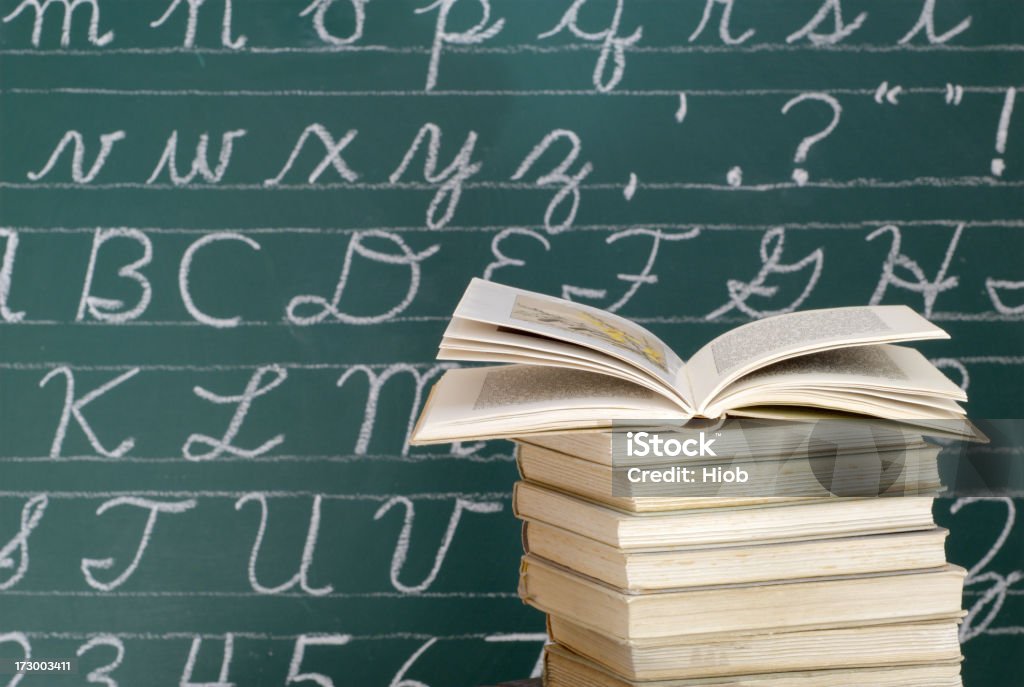 Books in front of a Blackboard book stack in front of a blackboard Spelling - Education Stock Photo