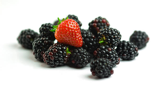 Blackberries and a strawberry on white background stock photo