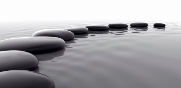 Studio-like royalty free 3d rendering of a row of shiny black pebbles.