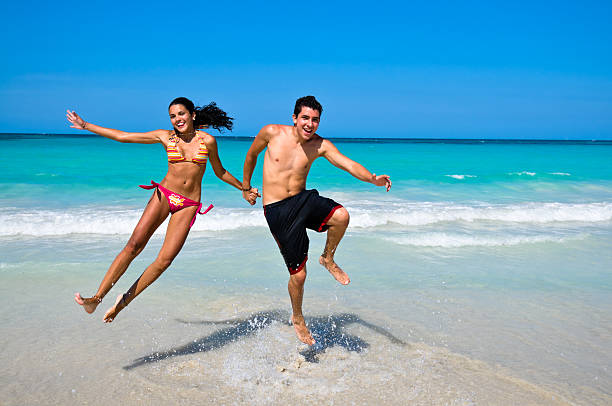 istock Young happy couple jumping holding hands in a tropical beach 173004445