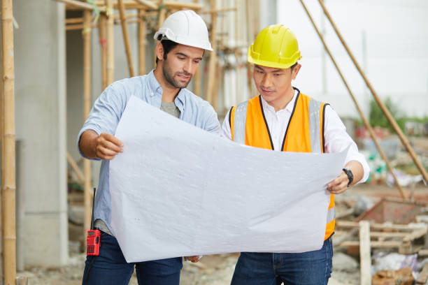 istock workers or architect holding plan blueprint paper at construction site 1730069750