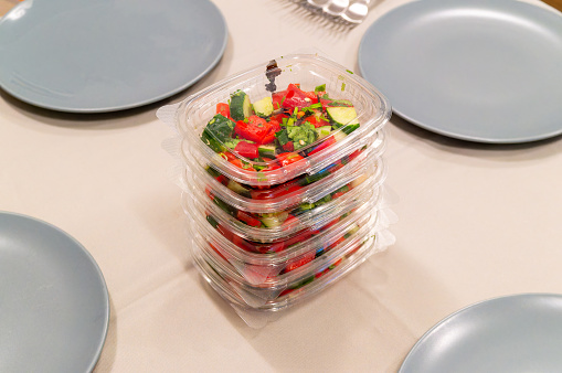 Vegetable salad in plastic containers on dining table
