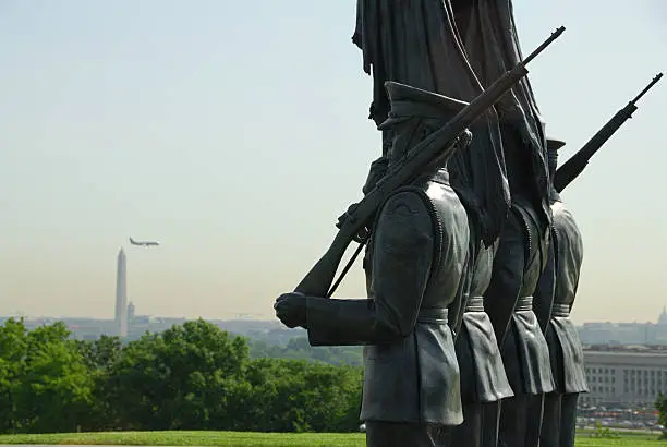 Perspective of the honor guard statue at the national memorial for those who have served in the U.S. Air Force.  Set against the Pentagon and the Washington Monument in the Washington DC area.