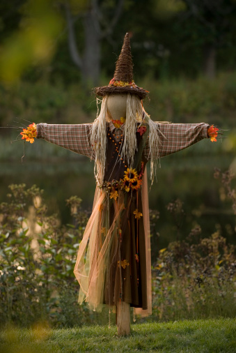 A faceless scarecrow stands in front of a lake during sunset. Tiny bit of digital grain due to slight increase in ISO.Shot with Nikkor 70-200 f/2.8