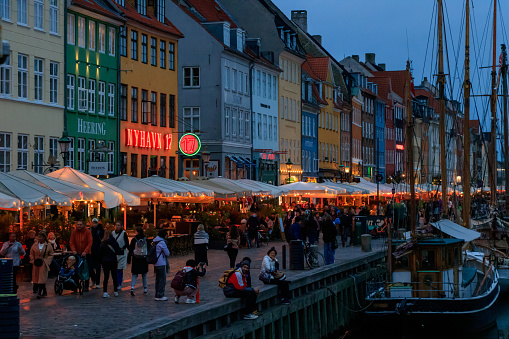 Nyhavn canal with its colorful houses at dusk with the lights on in Copenhagen, Denmark