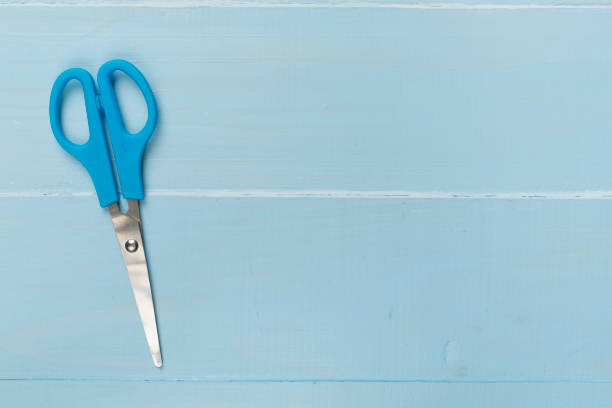 istock Blue scissors on wooden backgroung, top view 1730101620
