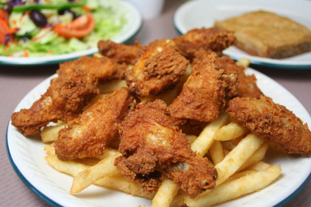 Fried chicken wings and French fries, served with salad and baklava.
