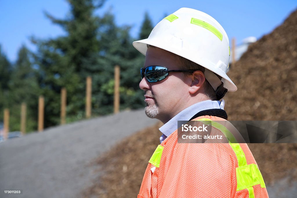 Male Construction Project Manager with safety gear yellow reflective Construction Project Manager overseeing a job site 30-39 Years Stock Photo