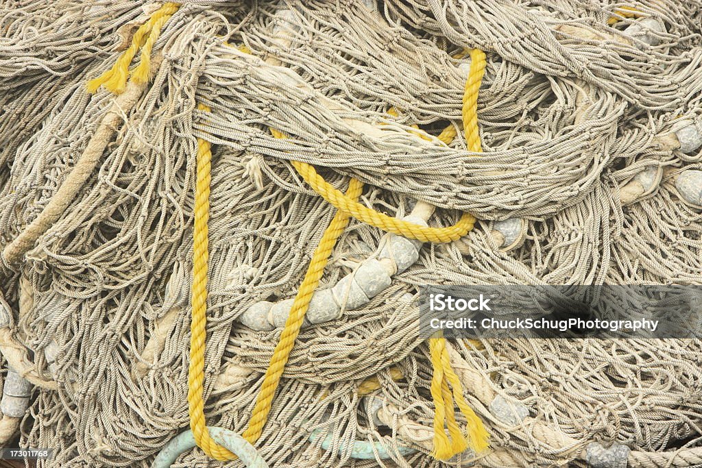 Nautical Fishing Net Rope Buoy Tangled pile of fishing nets ropes and buoys on harbor pier. Aquaculture Stock Photo