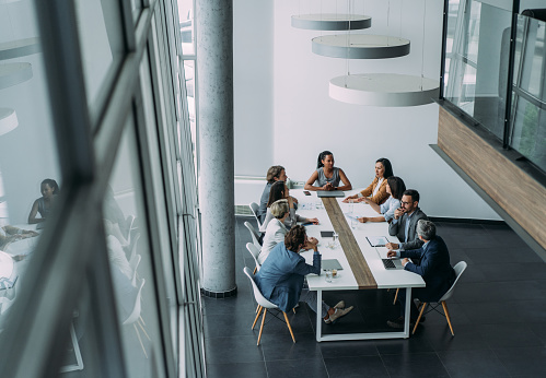 Above view of group of business persons in business meeting. Group of entrepreneurs on meeting in board room. Corporate business team on meeting in the office.