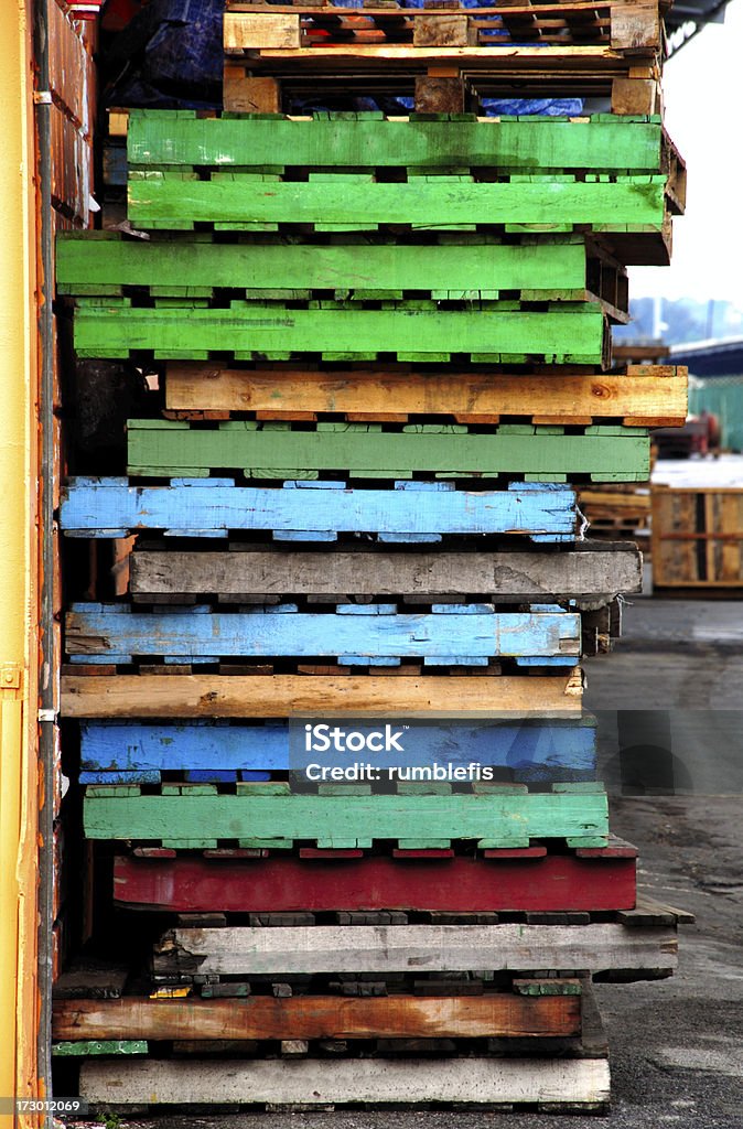 Coloured pallets Multi colours used pallets stacked at the road side Blue Stock Photo