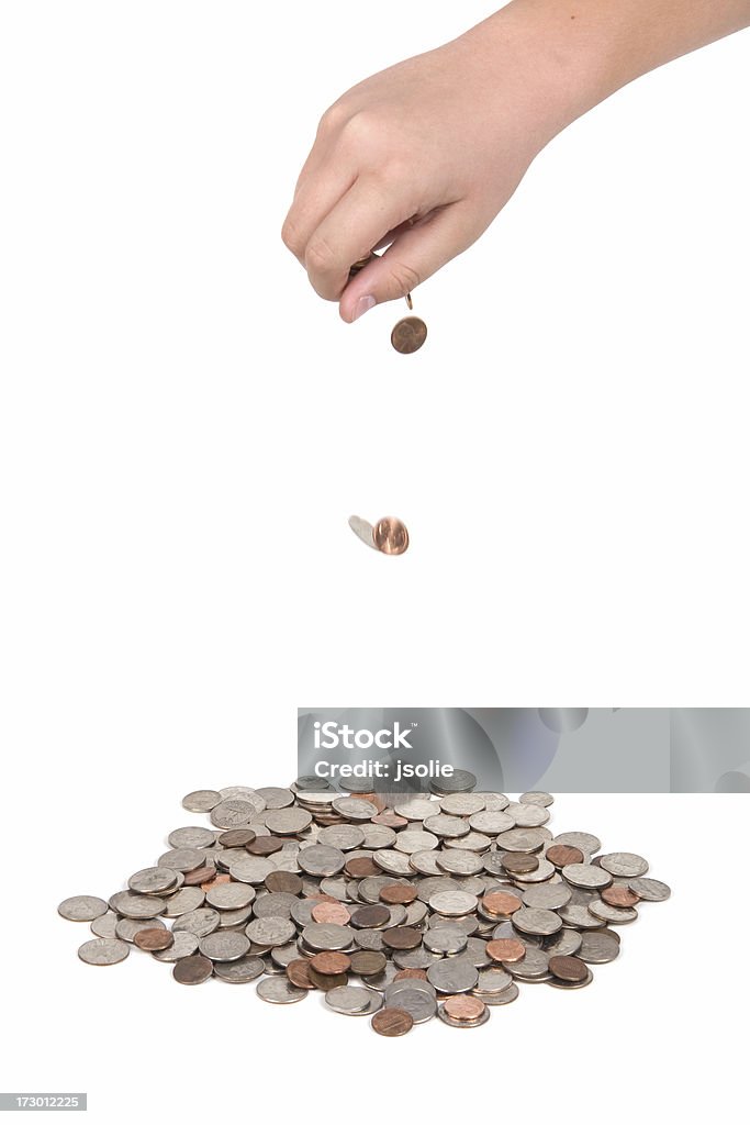 Hand dropping coins A hand drops coins into a big pile.  Isolated on white. Banking Stock Photo