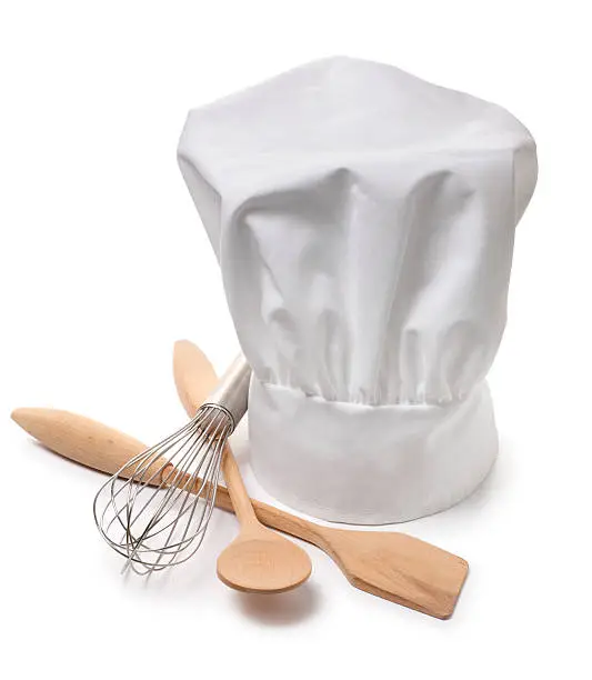 A chef's hat on white with cooking utensils. Clipping path included.