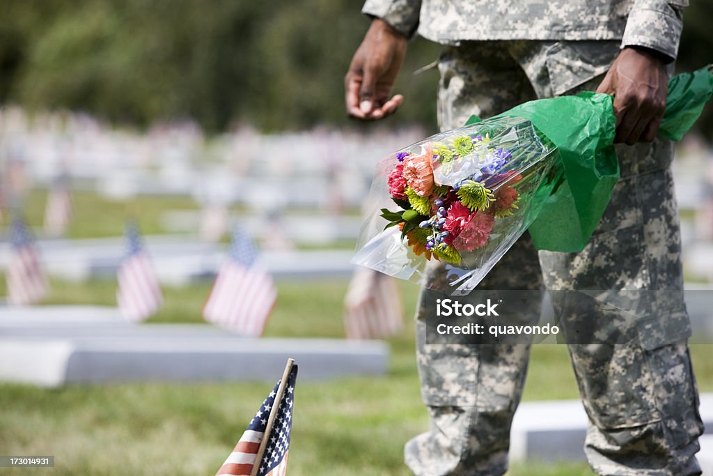 Army Soldier at Military Cemetery with Flower Bouquet, Copy Space United States Army soldier brings flowers to a Veteran's cemetery. Copy space. CLICK FOR SIMILAR IMAGES. African Ethnicity Stock Photo