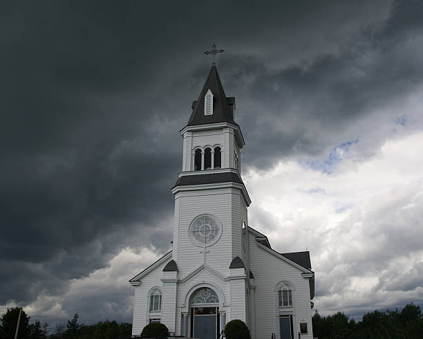 Igreja branca e nuvens de tempestade escuras - foto de acervo