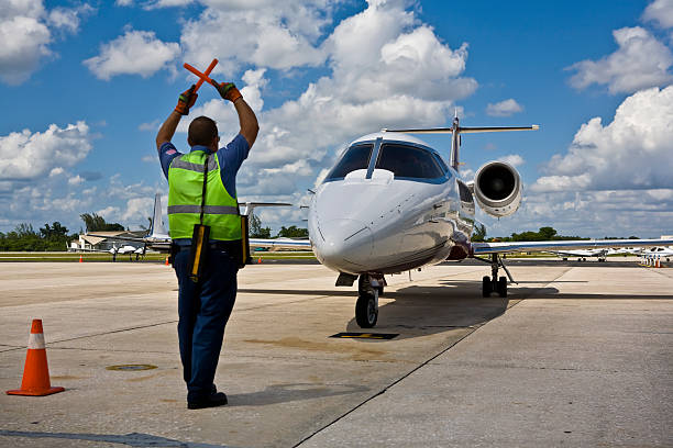 istock Ground Crew Guides a Private Jet into Parking Spot 173015334